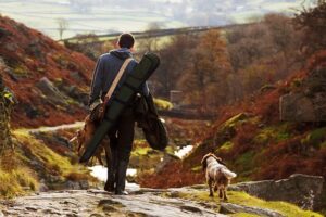 man and dog on shoot in countryside